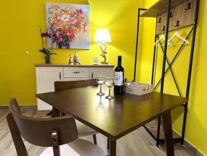 a dining room table with a bottle of wine and two glasses at Colorsphere in Thessaloniki +32 photos
