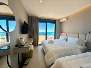 a hotel room with two beds and a view of the ocean at Hotel President in Shëngjin +60 photos