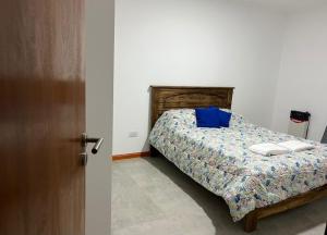 a bedroom with a bed with a blue pillow at Junín departamento in Junín