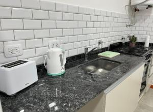 a kitchen counter with a sink and a toaster at Junín departamento in Junín