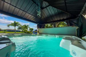 a large swimming pool with two chairs in the water at Waterfront House in Paradise at Cape Coral in Cape Coral
