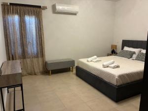 a bedroom with a bed and a chair and a window at Angela House in Symi