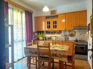 a kitchen with wooden cabinets and a table with chairs at Guest house near historical center in Vlorë +51 photos