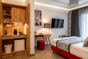 a hotel room with a bed and a desk and a sink at Garment District Suites in Athens