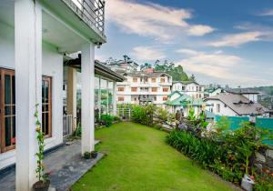 努沃勒埃利耶Villa Grand Mellow Nuwara Eliya的阳台享有庭院美景