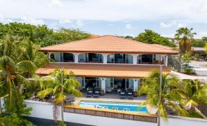 Una vista aérea de una casa con piscina y palmeras. en Atlantis Beach House, en Willemstad