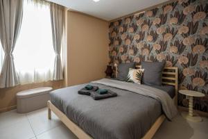 a bedroom with a large bed with a floral wallpaper at Bohème Palmeraie - Séjour mystique & unique à Blois in Blois