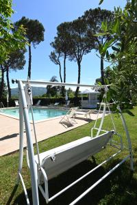 a swing in front of a swimming pool at Maiano Relais in Suio +22 photos