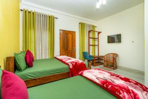 努沃勒埃利耶Villa Grand Mellow Nuwara Eliya的一间卧室配有两张床和一张桌子及一台电视机 更多74张照片