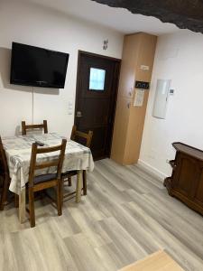 a dining room with a table and a flat screen tv at Casa San Antonio in Albarracín