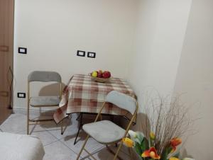 a table with two chairs and a plate of fruit on it at Casa del giglio in Cassibile