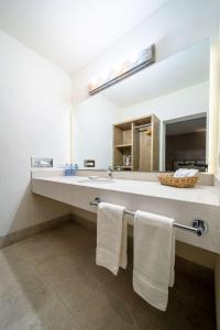 Un baño con lavabo, espejo y toallas. en Rincón Del Montero, en Parras de la Fuente 15 fotos más