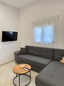 un soggiorno con un divano e un tavolo di Gold Coast Luxury Studio a Paralia Neas Triglias