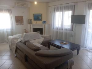 a living room with a couch and a table at Sweet Home in Platamonas