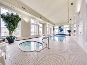 een grote badkamer met een hot tub in het midden bij Heritage Inn & Suites - Brooks in Brooks