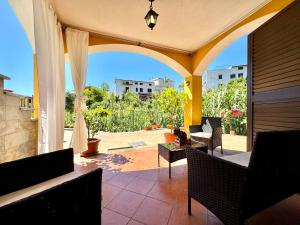 an outdoor patio with chairs and a view of a courtyard at Mediterranean Whisper in Santa Maria Navarrese