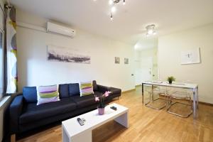 a living room with a black couch and a table at Plaza Espanya Apartment in Barcelona