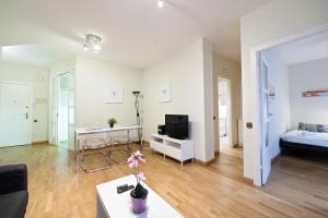 バルセロナにあるPlaza Espanya Apartmentのリビングルーム(ソファ、テーブル、テレビ付)