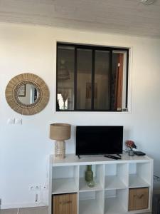 a television on a white shelf in a room at L Entre-Deux-Gîtes à Saint-Marcan-Baie du Mont-Saint-Michel in Saint-Marcan