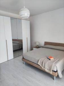 a bedroom with a bed with a book on it at A casa di Nonna Maria in Grottole