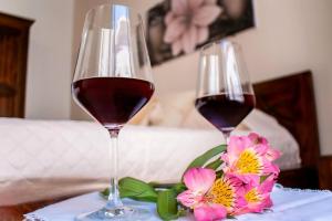 two glasses of wine on a table with flowers at Il Moro di Ossuna in Trapani
