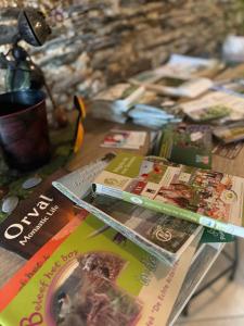 a table with magazines and books on top of it at Arduinna's Nest B&B in Neufchâteau