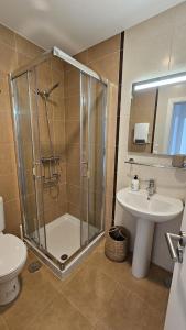 une salle de bain avec douche et lavabo dans l'établissement Apartamento a estrenar Mar de Cunchas, à San Martín de Arriba