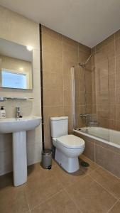 une salle de bain avec toilettes, lavabo et baignoire dans l'établissement Apartamento a estrenar Mar de Cunchas, à San Martín de Arriba 15 autres photos