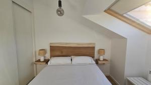 - une chambre avec un lit et deux lampes de chaque côté dans l'établissement Apartamento a estrenar Mar de Cunchas, à San Martín de Arriba