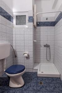 a bathroom with a toilet and a shower at Hotel Alexiou in Stomio