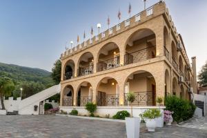 a large building with flags on top of it at Hotel Alexiou in Stomio