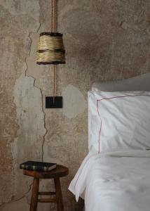 Un dormitorio con una cama y una mesa con una lámpara. en Convento Francescano Experience Hotel Cilento, en Cuccaro Vetere