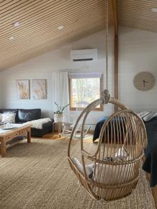 a living room with a rattan basket hanging from a ceiling at Rytkynranta Village 