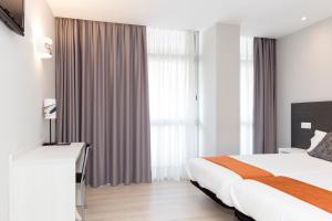 um quarto de hotel com uma cama e uma grande janela em Hostal Aslyp 114 em Barcelona