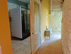 a bathroom with a walk in shower and a door at La hulotte de Labarthe in Mazères