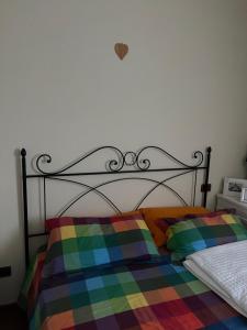 a bed with a multicolored blanket on top of it at Whynot book in Romano D'Ezzelino