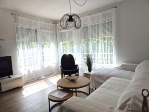 sypialnia z łóżkiem, krzesłem i telewizorem w obiekcie Deluxe Apartments Goya w mieście Zadar