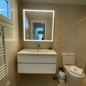a bathroom with a sink and a mirror and a toilet at Casa Florinda Tarifa in Tarifa +80 photos