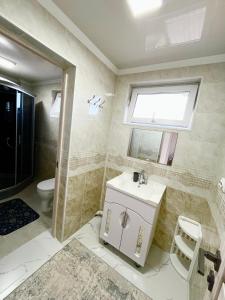 a bathroom with a sink and a toilet and a window at Sun House in Cholpon-Ata +7 photos