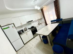 a small kitchen with a refrigerator and a table at Sun House in Cholpon-Ata