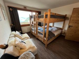 ヴェルビエにあるVerbier cozy Medran ski in ski outの二段ベッド2台とソファのある部屋