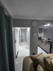 a living room with a couch and a kitchen at Upendorest in Gaborone