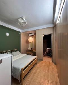 a bedroom with a bed and a green wall at PAPAYA HOTEL & Café 2 in Ho Chi Minh City