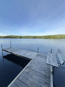 a dock on a lake with a bench on it at JOYFULL CAMP LIMIT 10 cottage in Naples