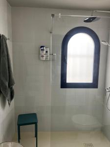 a shower with a window and a green stool in a bathroom at Meloneras ideal in Meloneras +31 photos