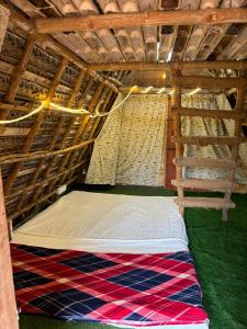 a bed in a tent with a hammock in it at Bamboo hutz in Jāmb