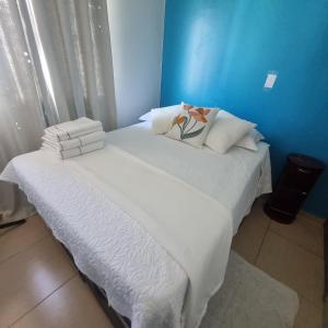 a bed with white sheets and pillows in a room at Apartamento completo com Wi-Fi, garagem em condomínio - Ideal para estadias tranquilas in Brasilia