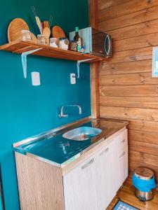 - une cuisine avec un évier et un mur bleu dans l'établissement Top Cabana Romântica Serra Catarinense - Anitápolis SC, à Annitapolis