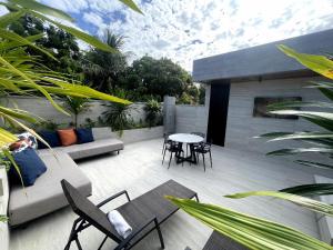 a patio with a couch and chairs and a table at Motel UP (Adult Only) in Fortaleza