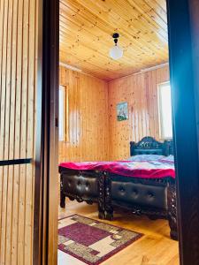 a room with a bed in a wooden room at Bata GuesThouse in Adishi